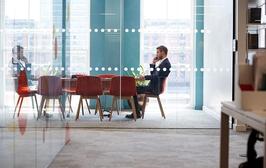 businessman thinking in a glass-sided boardroom