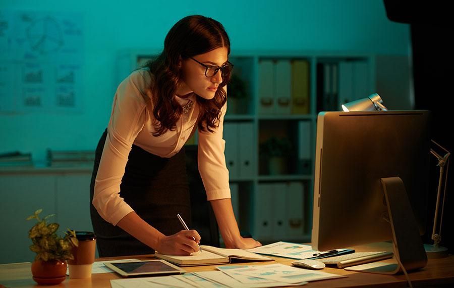 woman taking notes from a computer screen