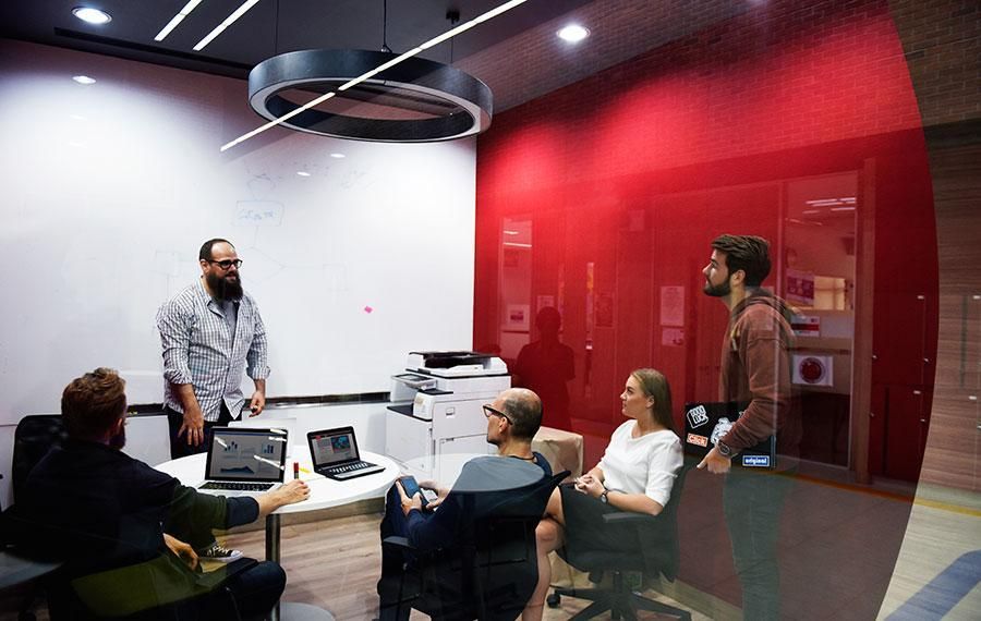 Bearded man presenting to his colleagues
